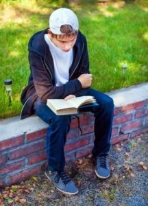 Boy reading on curb